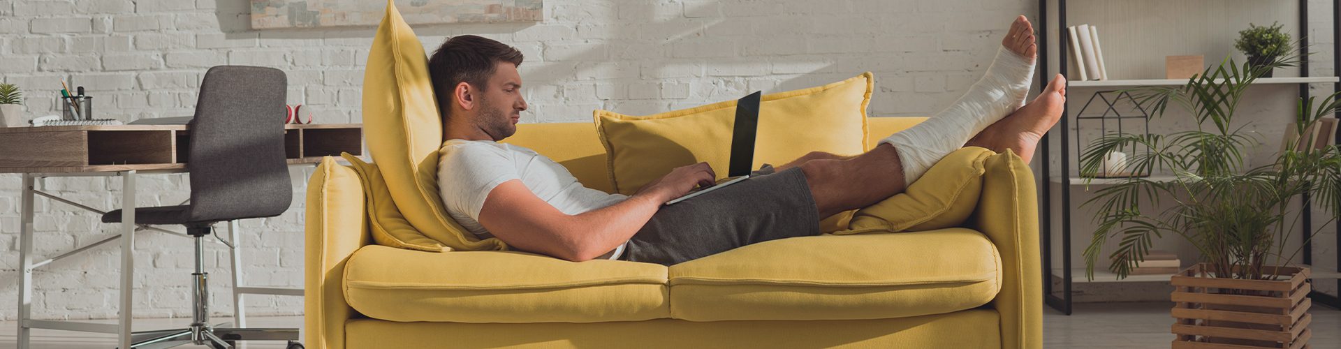 Mand med brækket ben i sofa