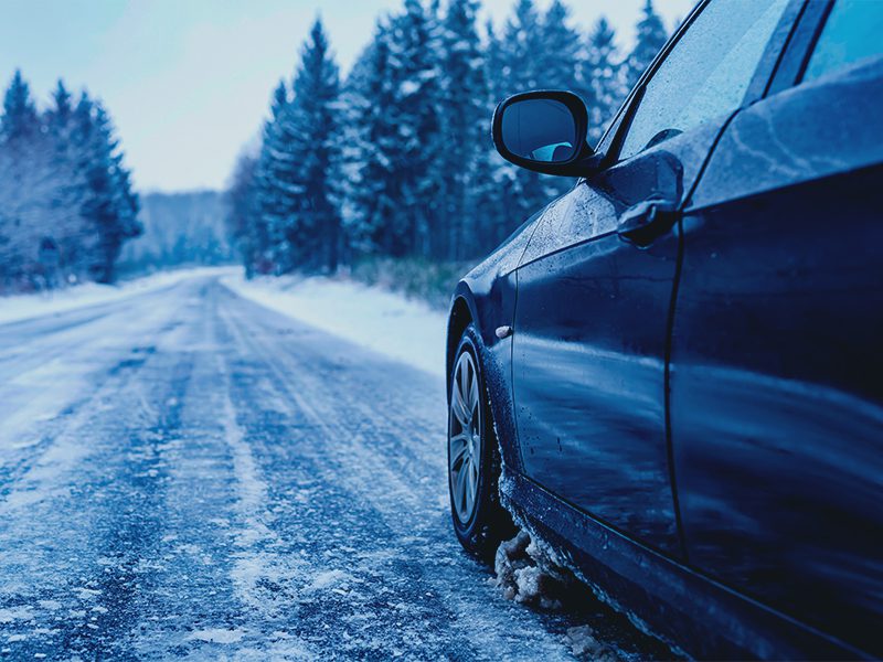 Bil kører på vej med sne