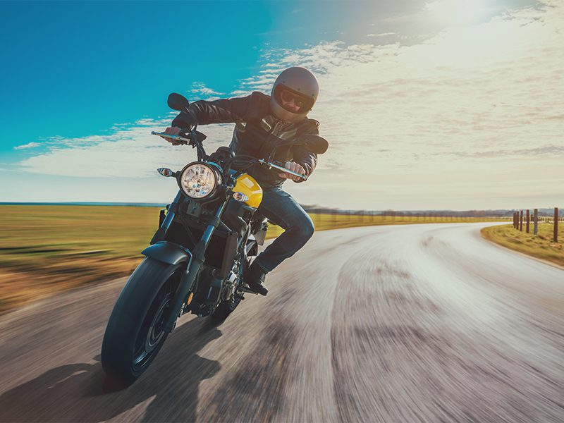 Mand på motorcykel i fart