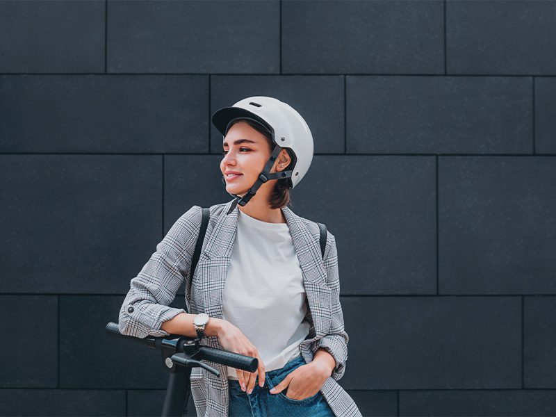 Pige på el-løbehjul med cykelhjelm