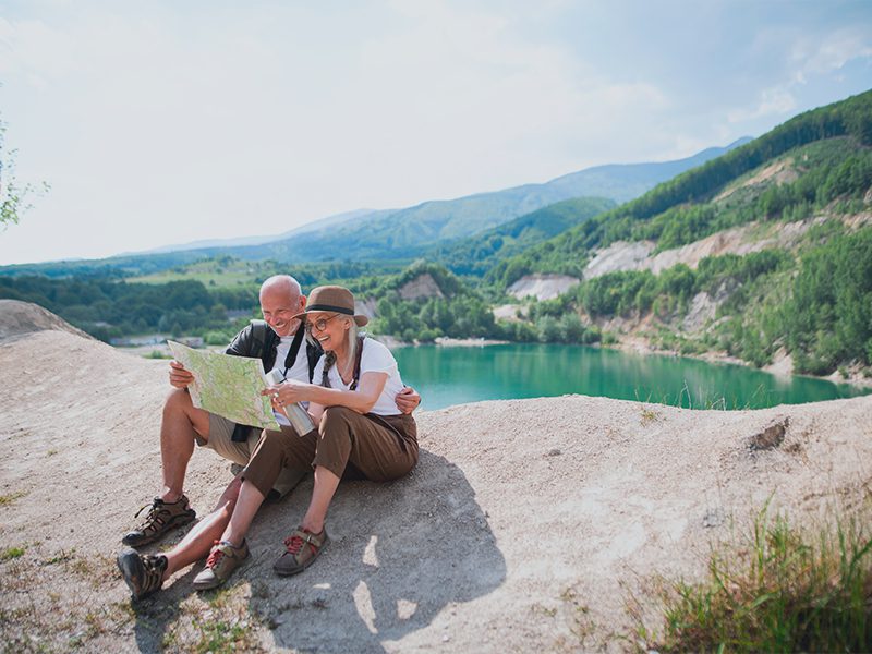 Ældre par kigger på kort på vandretur i naturen