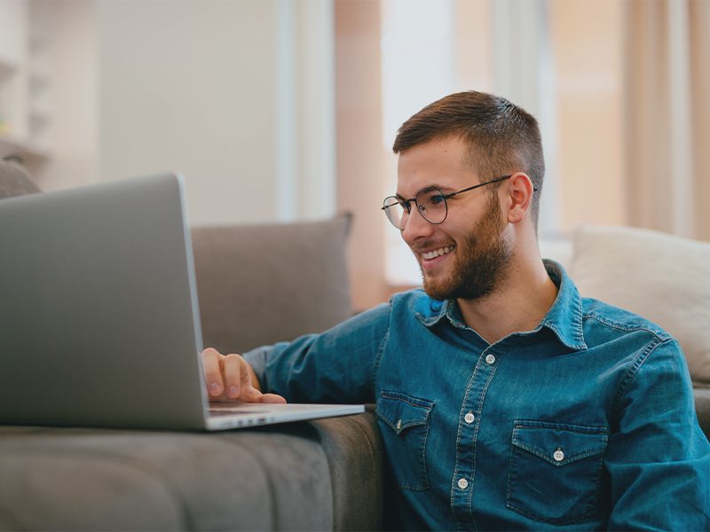 Smilende mand ved computer